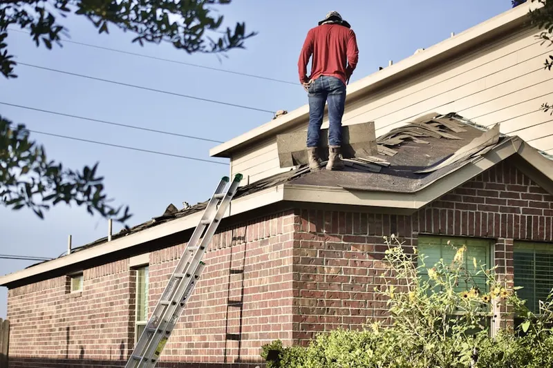 Professional roofer working on a residential roof in Kalkaska